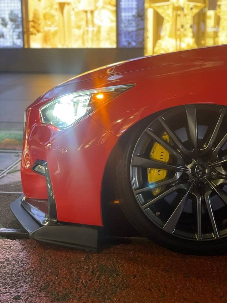 Close-up of a red Infiniti Q50 front wheel with yellow painted calipers